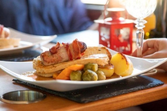 a person sitting at a table with a plate of food