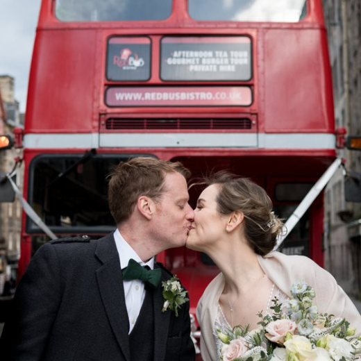 a man and a woman standing in front of a bus